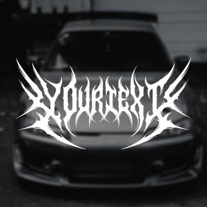 Puede incluir: Texto blanco estilizado "YOURTEXT" en una fuente gótica con bordes afilados y puntiagudos. El texto está centrado sobre la parte delantera de un coche oscuro, con los faros y el capó visibles. El fondo está borroso.