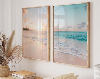 May include: Two framed prints of a beach scene with turquoise water and white sand. The prints are in wooden frames with a light brown finish.