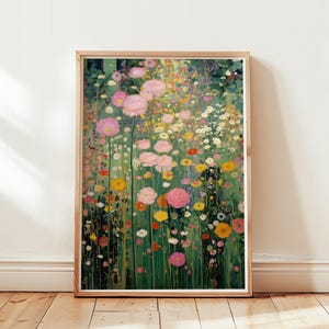 Op de afbeelding: Een ingelijste kunstdruk met een kleurrijk bloemenveld. Het kunstwerk toont een verscheidenheid aan bloemen in tinten roze, geel en wit tegen een groene achtergrond. De print is ingelijst in een lichtbruine houten lijst, wat een vleugje warmte toevoegt.