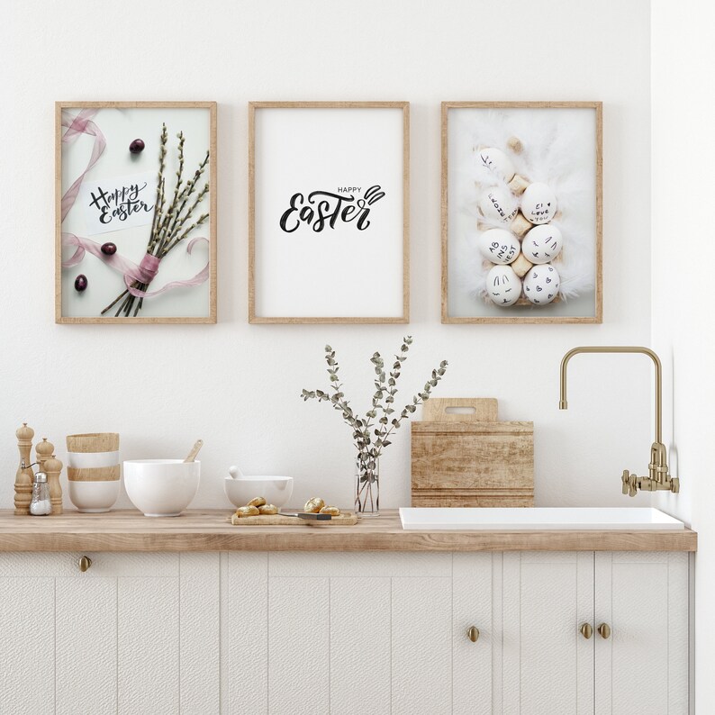 May include: Three framed prints with Easter-themed designs. The left print features a bouquet of pussy willow branches with a pink ribbon and the text "Happy Easter". The center print features the text "Happy Easter" in a stylized font. The right print features a white bunny rabbit with a nest of white eggs decorated with black ink.
