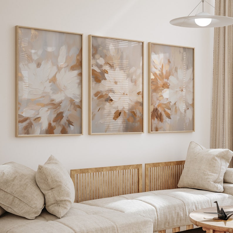 May include: Three framed abstract paintings with a muted color palette of beige, brown, and white. The paintings feature a floral design with brushstrokes that create a textured effect.