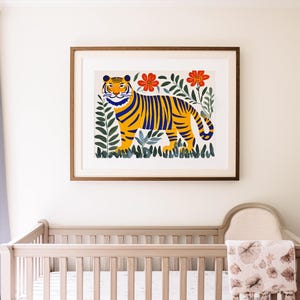 May include: A framed illustration of a yellow and blue tiger with black stripes standing in a jungle setting with green leaves and red flowers.