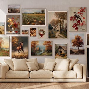 May include: A collection of framed vintage-style landscape and still-life paintings in warm autumnal tones. The artwork includes scenes of fields, trees, a horse, and a bird, arranged above a beige sofa.