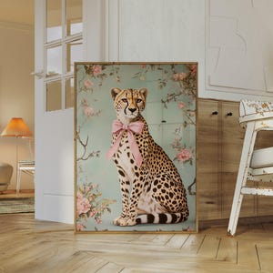 May include: A cheetah wearing a pink bow sits in front of a floral background. The cheetah is looking directly at the viewer. The background is a light blue with pink and white flowers.