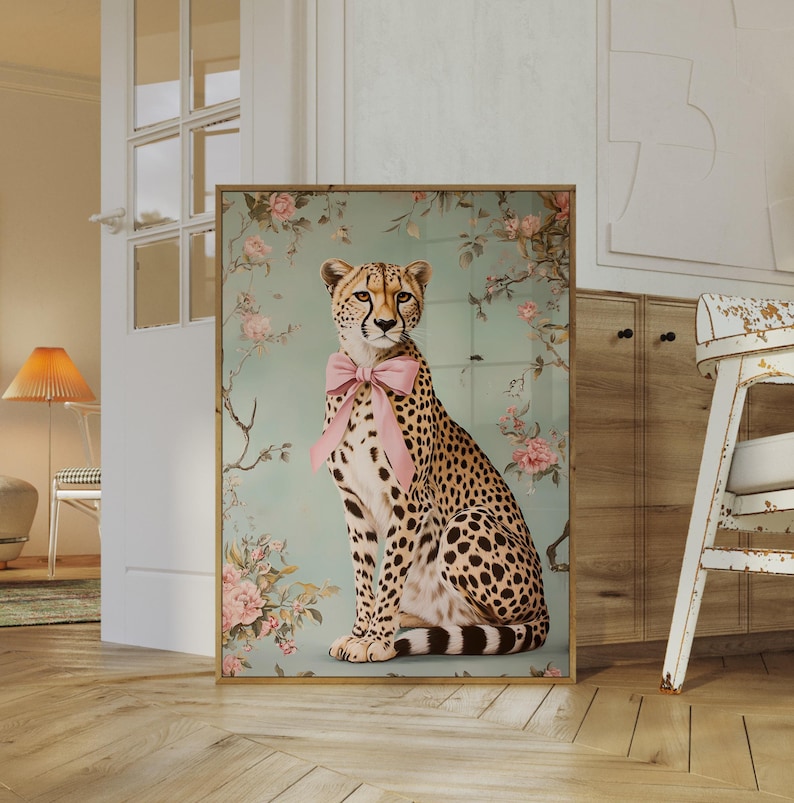 May include: A cheetah wearing a pink bow sits in front of a floral background. The cheetah is looking directly at the viewer. The background is a light blue with pink and white flowers.