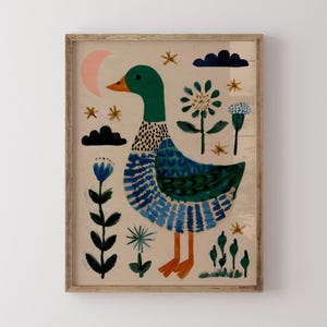 Puede incluir: Una impresi&oacute;n art&iacute;stica enmarcada con una ilustraci&oacute;n caprichosa de un pato. El pato tiene una cabeza verde y un cuerpo azul. La obra de arte incluye una luna creciente rosa, estrellas, flores y nubes azul oscuro. El pato tiene pies y pico naranjas.