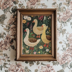 May include: A framed painting of three geese in a green field with flowers. The geese are white with orange beaks and feet. The painting is in a brown wooden frame.