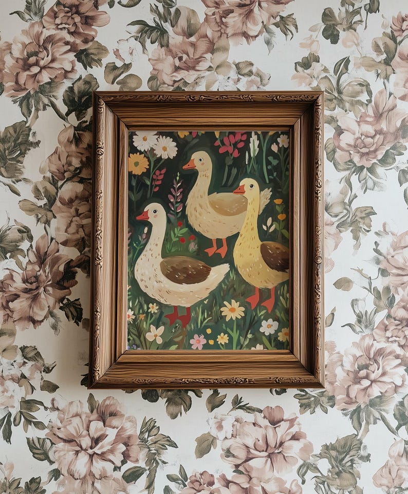 May include: A framed painting of three geese in a green field with flowers. The geese are white with orange beaks and feet. The painting is in a brown wooden frame.