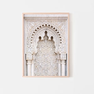 May include: A framed print of a white marble archway with intricate carvings. The archway is decorated with a repeating geometric pattern.