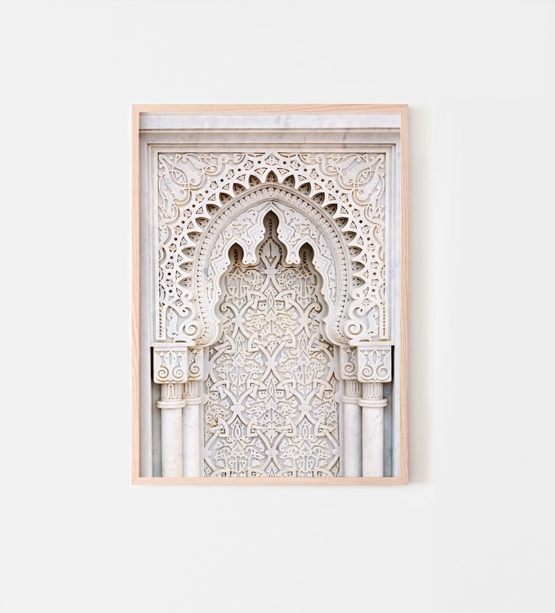 May include: A framed print of a white marble archway with intricate carvings. The archway is decorated with a repeating geometric pattern.