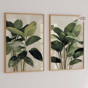 Puede incluir: Dos l&aacute;minas bot&aacute;nicas enmarcadas con exuberantes hojas verdes sobre un fondo neutro. La obra de arte est&aacute; encerrada en marcos de madera marr&oacute;n claro, creando una est&eacute;tica natural y elegante. Ideales para a&ntilde;adir un toque de naturaleza a cualquier espacio interior.