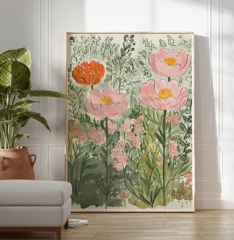 K&ouml;nnte beinhalten: Ein gerahmter Kunstdruck mit einer Gartenszene mit gro&szlig;en rosa und orangefarbenen Blumen. Das Kunstwerk hat einen Aquarellstil mit gr&uuml;nem Laub und einem hellen Hintergrund. Der Druck wird in einem Raum mit neutraler Farbpalette ausgestellt.
