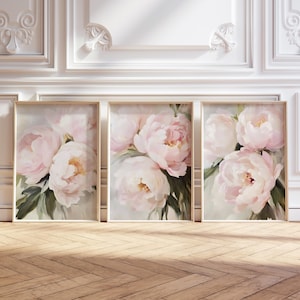 May include: Set of three framed floral art prints. Each print features a close-up of soft pink peonies with green leaves against a light background. The frames are a light wood color, and the overall aesthetic is elegant.