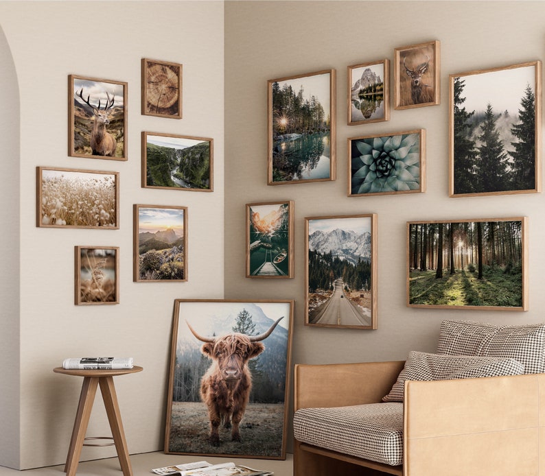 May include: A gallery wall with a variety of framed prints, including nature scenes, animals, and abstract designs. The prints are arranged in a symmetrical pattern on a light beige wall.