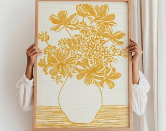 May include: A framed art print featuring a yellow floral illustration in a vase. The artwork is a line drawing style with a light beige background and a natural wood frame. The flowers are stylized and the overall aesthetic is minimalist.
