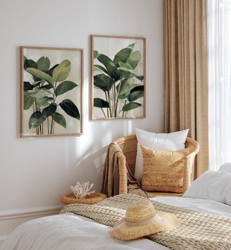 Puede incluir: Dos impresiones bot&aacute;nicas enmarcadas con pinturas de acuarela de exuberantes hojas verdes. Las impresiones est&aacute;n sobre una silla de mimbre con almohadas y un sombrero de paja en una cama, creando una est&eacute;tica serena y natural.