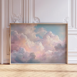 Könnte beinhalten: Ein gerahmter Kunstdruck mit einer pastellfarbenen Wolkenlandschaft. Das Kunstwerk zeigt flauschige, weiße Wolken mit rosa und pfirsichfarbenen Tönen vor einem hellblauen Himmel. Der Druck ist in einem einfachen, hellen Holzrahmen eingefasst.