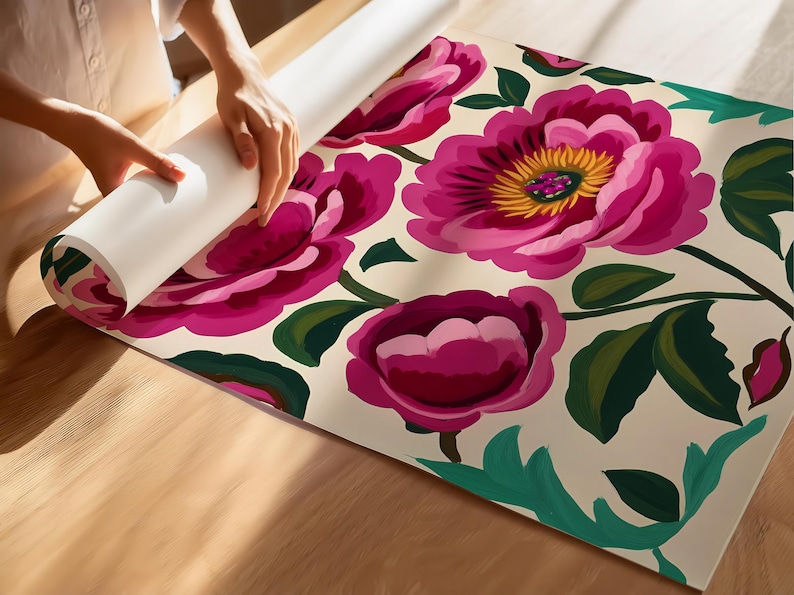Puede incluir: Un rollo de papel tapiz con estampado floral rosa y verde sobre fondo blanco. El papel tapiz est&aacute; siendo desenrollado por una mano.