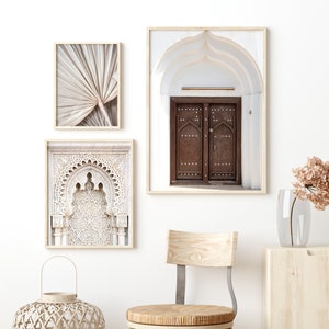 May include: Three framed prints with a Moroccan theme. The prints feature a close-up of an ornate archway, a traditional wooden door, and a palm leaf.