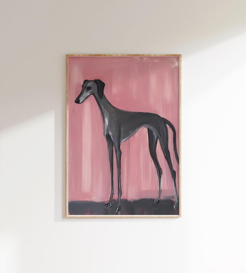 Puede incluir: Pintura enmarcada de un galgo. El perro est&aacute; representado en un estilo minimalista con un cuerpo y patas largos y delgados. El fondo es rosa suave con una base gris oscuro.