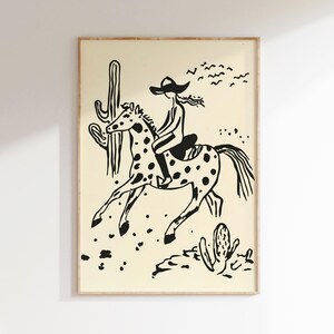 May include: Black and white illustration of a person riding a horse through a desert landscape. The person is wearing a cowboy hat and the horse has spots. There are cacti in the background.