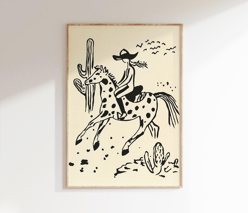 May include: Black and white illustration of a person riding a horse through a desert landscape. The person is wearing a cowboy hat and the horse has spots. There are cacti in the background.