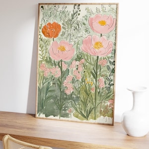 K&ouml;nnte beinhalten: Ein gerahmter Kunstdruck mit Blumenmotiven, der eine Aquarellmalerei von rosa und orangefarbenen Blumen mit gelben Zentren vor einem Hintergrund aus gr&uuml;nem Laub zeigt. Das Kunstwerk wird auf einer Holzoberfl&auml;che ausgestellt, mit einer wei&szlig;en Vase und einem Stuhl im Hintergrund.