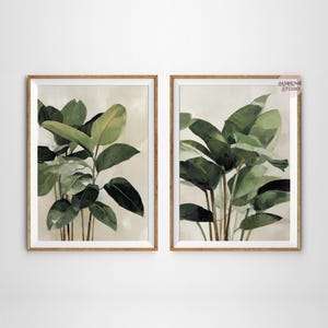 Puede incluir: Dos impresiones bot&aacute;nicas enmarcadas con exuberantes hojas verdes sobre un fondo neutro. La obra de arte tiene un efecto acuarela, con diferentes tonos de verde y marr&oacute;n. Los marcos de color marr&oacute;n claro a&ntilde;aden un toque natural a la decoraci&oacute;n.