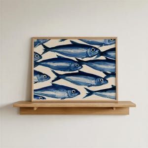 May include: A rectangular framed art print featuring a repeating pattern of stylised fish painted in various shades of blue against a cream-coloured background. The fish are depicted with visible brushstrokes, dark blue outlines, and simple circular eyes.