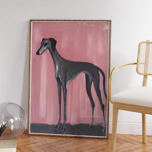 Puede incluir: Una impresi&oacute;n art&iacute;stica enmarcada que presenta un galgo gris sobre un fondo rosa y gris. La obra de arte est&aacute; en un marco de madera, cerca de una silla con marco dorado y una esfera de cristal.