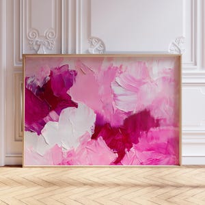Könnte beinhalten: Abstraktes Gemälde mit rosa, weißen und roten Pinselstrichen. Das Gemälde ist in einem hellen Holzrahmen gerahmt.