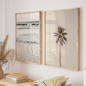 May include: Two framed prints, one depicting a beach scene and the other a palm tree. The beach print shows a sandy beach with waves breaking on the shore. The palm tree print shows a single palm tree against a light background.