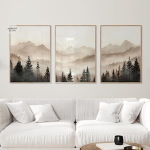May include: A set of three rectangular wall art prints featuring a misty mountain landscape with dark evergreen trees in the foreground and light beige, hazy mountains in the background. The text JAMHOME STUDIO is visible in the top left corner.