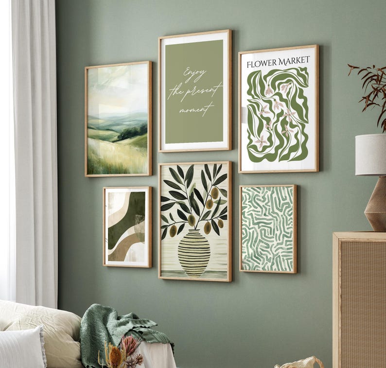 May include: A collection of six framed art prints with a nature theme. The prints feature landscape scenes, abstract designs, and botanical illustrations. One print reads "Enjoy the present moment." The color palette includes shades of green, brown, and white.