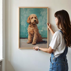 May include: A framed painting of a brown and white dog sitting on a blue background. The dog is looking up at the viewer.