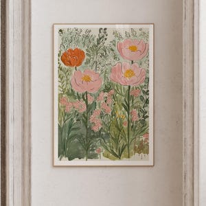 K&ouml;nnte beinhalten: Aquarell-Kunstdruck mit gro&szlig;en rosa und orangefarbenen Blumen mit gelben Zentren, vor einem Hintergrund aus gr&uuml;nem Laub. Das Kunstwerk ist in einem hellen Holzrahmen gerahmt und schafft ein botanisches Thema.