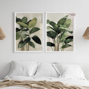 Puede incluir: Dos impresiones bot&aacute;nicas enmarcadas con ilustraciones en acuarela de exuberantes plantas verdes con hojas grandes. La obra de arte est&aacute; sobre un fondo neutro y enmarcada en blanco, creando una est&eacute;tica serena y natural.