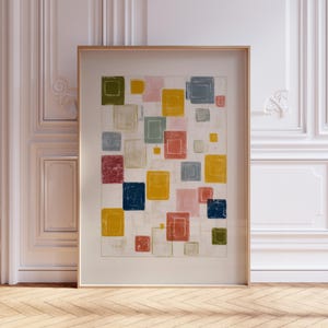 Può includere: Stampa artistica astratta con un motivo di quadrati colorati nelle tonalità di giallo, rosa, blu, verde e rosso. L'opera d'arte è incorniciata in una cornice di legno chiaro. I quadrati sono disposti su uno sfondo bianco.