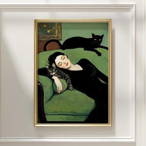 May include: A framed art print depicts a woman in a black dress reclining on a green sofa with two cats. One cat rests on the sofa, while the other is curled up next to the woman. The artwork has a vintage aesthetic with a gold frame.