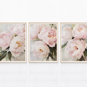 May include: Set of three framed floral art prints. Each print features a close-up of soft pink peonies with yellow centers and green leaves. The artwork is set against a light background, creating a delicate and elegant aesthetic.