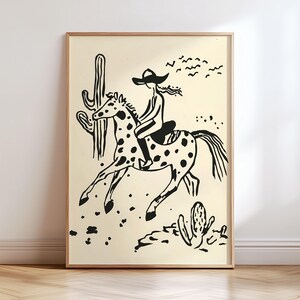 May include: Black and white illustration of a person riding a horse in a desert landscape. The person is wearing a cowboy hat and the horse has spots. There are cacti and birds in the background.