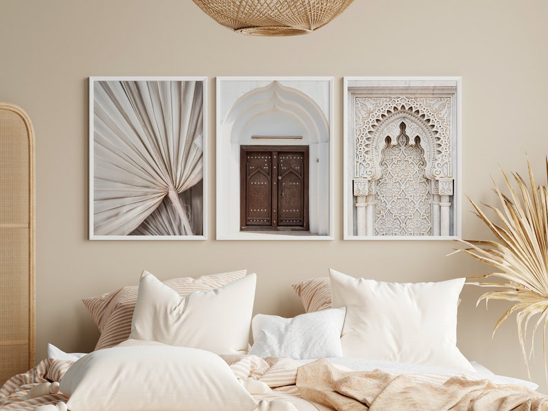 May include: Three framed prints in a bedroom setting. The prints feature a close-up of a palm leaf, a wooden door with intricate details, and a white archway with ornate carvings.