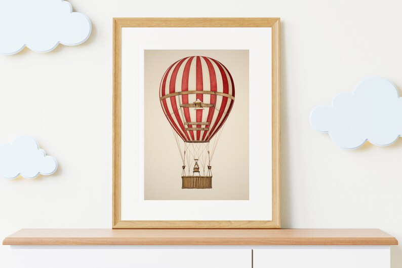 May include: A framed print of a red and white striped hot air balloon with a wicker basket. The balloon is floating in the air against a beige background.