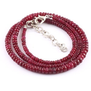 Op de afbeelding: Een rode robijn kralenketting met een zilveren sluiting. De ketting is gemaakt van kleine, ronde kralen en is ongeveer 45 cm lang.