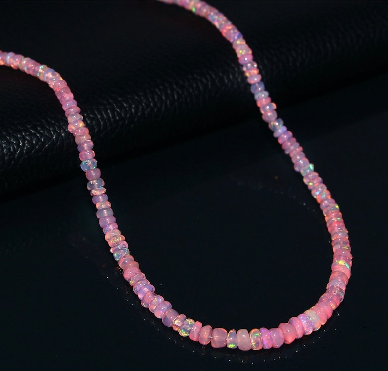 Puede incluir: Un delicado collar de cuentas de &oacute;palo rosa. El collar est&aacute; hecho de peque&ntilde;as cuentas redondas que est&aacute;n enhebradas en una cadena fina. Las cuentas son de color rosa p&aacute;lido con un ligero brillo iridiscente.