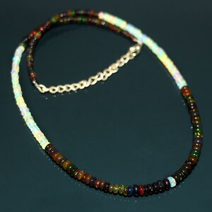 May include: A silver chain necklace with a multi-coloured opal bead strand. The strand is made of alternating white and dark opal beads.