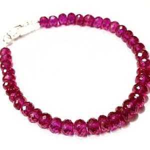 May include: A bracelet made of faceted ruby beads with a silver clasp.