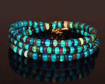 Può includere: Una collana multifilo realizzata con perline di opale iridescente in tonalità di blu, verde e viola. Le perline sono infilate su una catena d'oro.