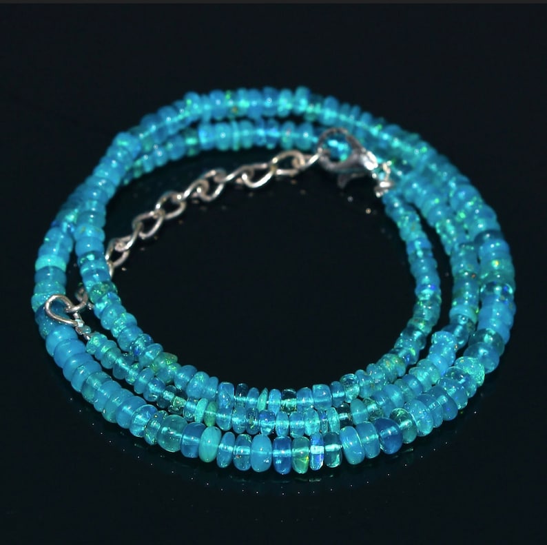 Puede incluir: Un collar de piedras preciosas de &oacute;palo azul turquesa con un cierre de plata. El collar est&aacute; hecho de peque&ntilde;as cuentas redondas y est&aacute; en capas para un look delicado.