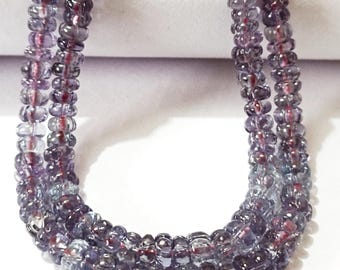 May include: A strand of purple and blue gemstone beads. The beads are faceted and have a slightly iridescent finish.